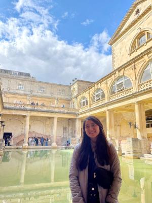 Woman posing by Roman baths in England